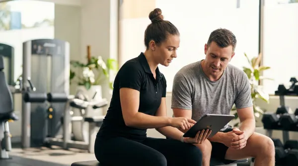 Personal trainer consulting a client in the gym